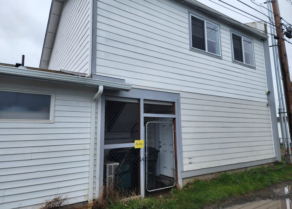 White house with fenced area.