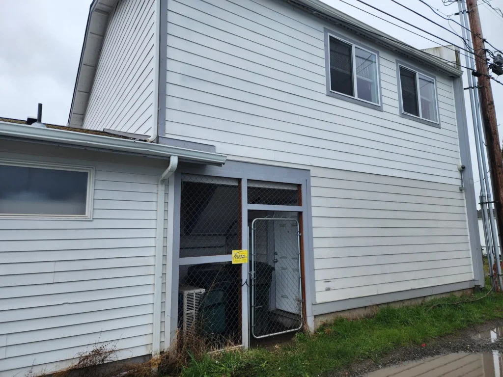 White house with fenced area outside.